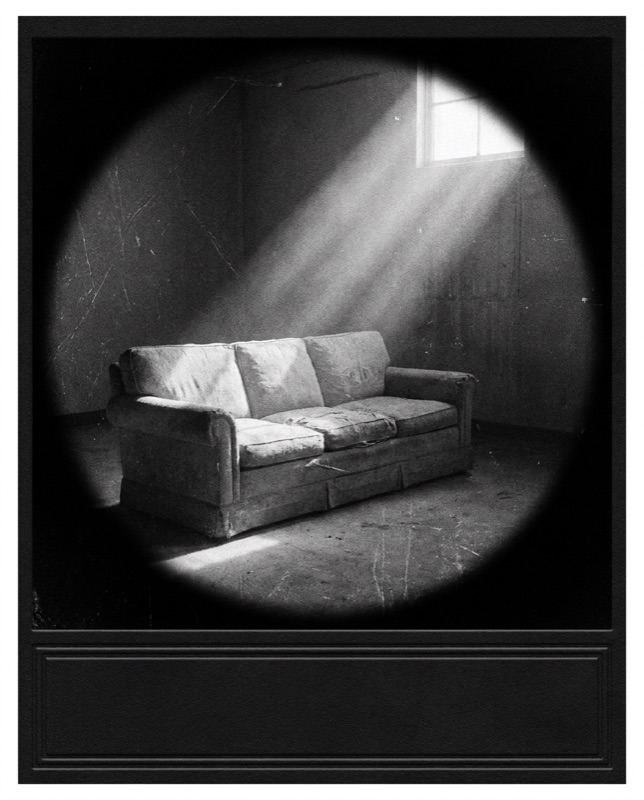 A worn couch in an empty room